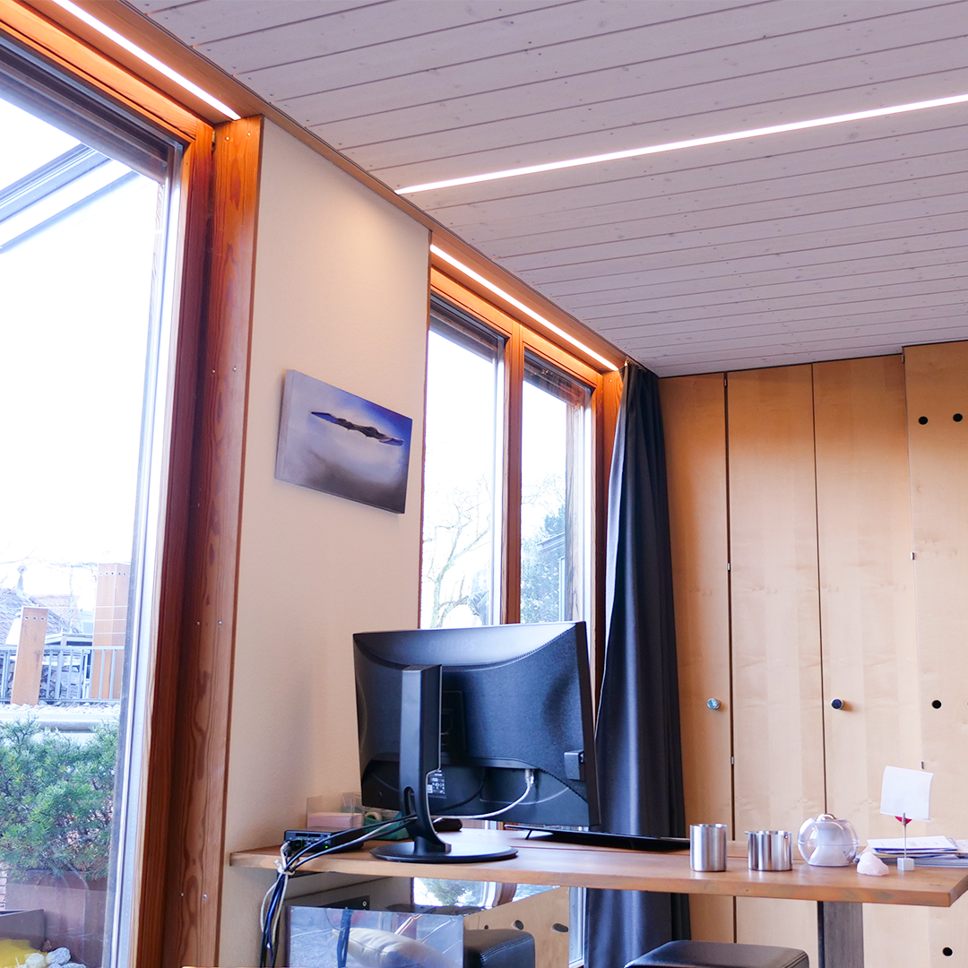 Die LED-Profilleuchten in der Holzdecke in der Attika in Arlesheim verschmelzen komplett in Gesamtbild der Wohnung.