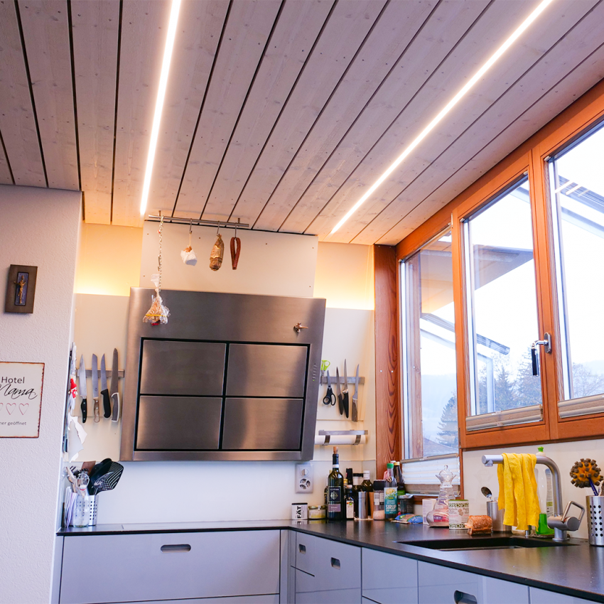Die LED-Profilleuchten in der Holzdecke in der Attika in Arlesheim verschmelzen komplett in Gesamtbild der Wohnung.